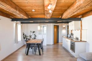 a kitchen and dining room with a wooden ceiling at Altes Schulhaus in Heiligenberg