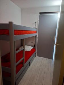 a small room with two bunk beds and a door at Studio Hyper centre - Ski in Villard-de-Lans