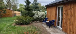 a patio with two chairs and a table in a yard at Sosnowy Zakątek, Laskowo in Laskowo