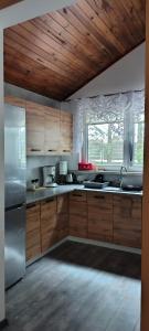 a kitchen with wooden cabinets and a white refrigerator at Sosnowy Zakątek, Laskowo in Laskowo