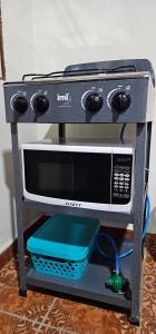 a microwave oven sitting on a stand on a table at María House in San Miguel