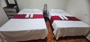 two beds sitting next to each other in a room at María House in San Miguel
