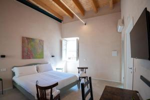 a bedroom with a bed and two chairs and a table at Borgo Puglia in Bisceglie