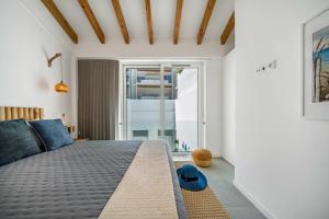 a bedroom with a bed and a large window at The Blue House - Mediterranean Loft in Faro