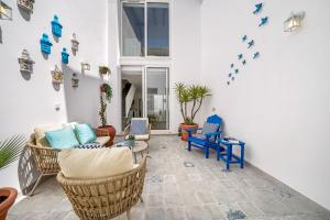 a living room with wicker furniture and blue chairs at The Blue House - Mediterranean Loft in Faro