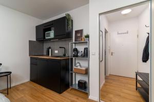 a kitchen with black cabinets and a counter top at Litzi's zentrales Apartment mit Parkplatz in Hockenheim