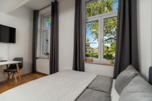 a bedroom with a bed and two windows at Litzi's zentrales Apartment mit Parkplatz in Hockenheim