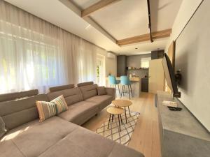 a living room with a couch and a table at Bright Apartment with Balcony near Bus and Train in Mostar +8 photos