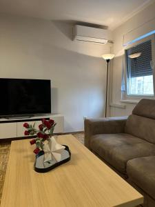 a living room with a couch and a table with flowers on it at Salt City Apartments in Sepetari +1 photo