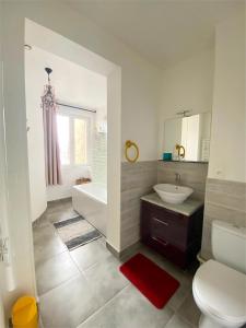 a bathroom with a toilet and a sink and a tub at La Mignonette in Épernay +47 photos