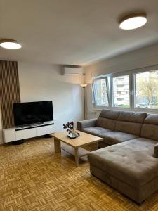 a living room with a couch and a flat screen tv at Salt City Apartments in Sepetari