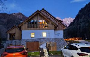 a house with two cars parked in front of it at Gostišče Jezersko in Zgornje Jezersko