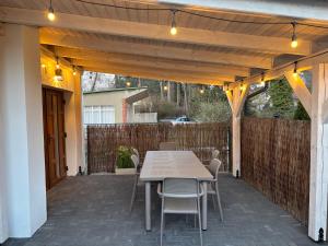 a patio with a table and chairs under a pergola at Wczasy Boszkowo in Boszkowo