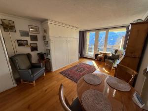 a living room with a table and chairs at Blüemlisalp 712 Studio in Beatenberg