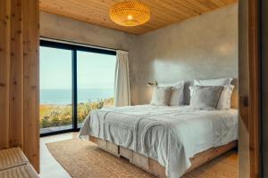 a bedroom with a bed and a large window at Casa do Alecrim in São Roque do Pico