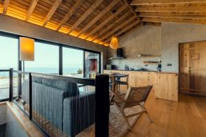 a kitchen and dining room with a view of the ocean at Casa do Alecrim in São Roque do Pico