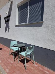 two chairs and a table and a table and chairs against a building at Apartman Edwin Jajce in Jajce