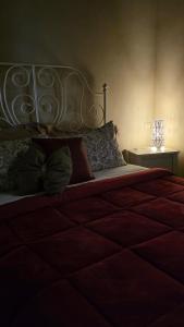 a bedroom with a large bed with a red comforter at Le Contrade in Amelia
