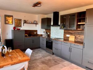a kitchen with gray cabinets and a wooden table at Ferienwohnung Rosengarten in Einbeck
