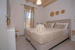a bedroom with a large bed and a window at Mystic Harmony in Mikonos +160 photos