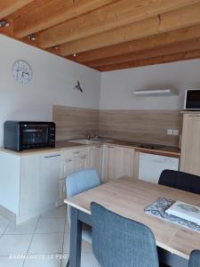a kitchen with a table and a microwave at L etoile bleue in Fossé