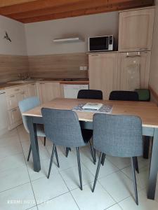 a kitchen with a wooden table and chairs at L etoile bleue in Fossé +17 photos