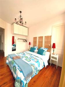 a bedroom with a large bed with blue pillows at La Mignonette in Épernay