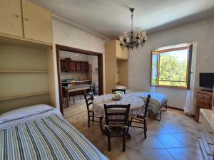 a room with a table and chairs and a kitchen at La Casa in Piazza in Toffia
