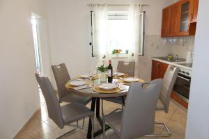 a dining room table and chairs in a kitchen at Apartman Perina in Trogir