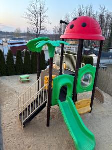 a playground with a green slide in a sandbox at Wczasy Boszkowo in Boszkowo