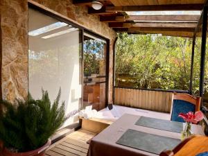 a balcony with a table and a large window at CABAÑAS MONTEVERDE - Guarne ANT in Guarne