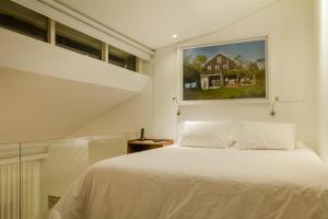 a bedroom with a white bed and a painting on the wall at The Grace Hotel in Bogotá +31 photos