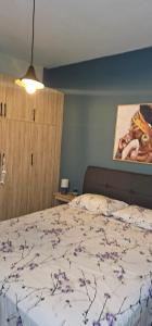 a bedroom with a bed and a painting on the wall at Alora House in Kefalos