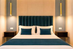 a bedroom with a large bed with blue and white pillows at Museo Suite in Naples