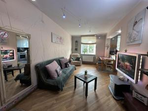 a living room with a couch and a tv at Andrea Apartamenti in Jūrmala