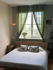 a bedroom with a bed with two pillows and a window at Andrea Apartamenti in Jūrmala