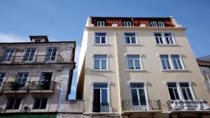 a tall white building with windows and balconies at Find Me Inn Boutique Penthouse in Lisbon