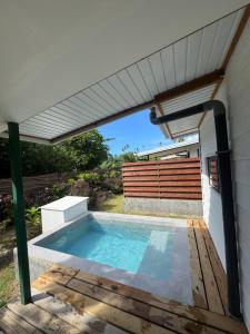 a swimming pool in a backyard with a pergola at Tiny House Moorea Hinavai in Papetoai