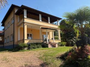 a house with a palm tree in front of it at Vista Bella - Villa Giulia in Porto Valtravaglia