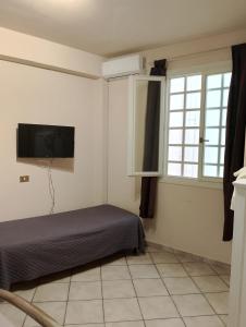 a bedroom with a bed and a flat screen tv at Sea life Terrasini in Terrasini