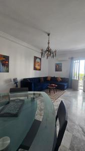 a living room with a glass table and a couch at Beau appt vue mer à gammarth in Gammarth +8 photos