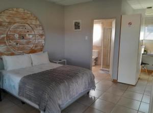 a bedroom with a bed with a wooden headboard at Die Skuur Douglas in Douglas