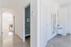 a white room with a mirror and a bedroom at Domus Afrodite - Torre Squillace in Torre Squillace +37 photos