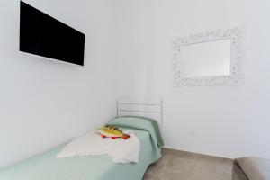 a white room with a tv and a couch at Domus Afrodite - Torre Squillace in Torre Squillace