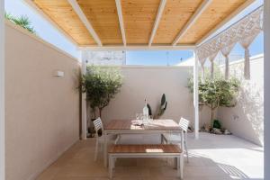 a table and chairs on a patio with a wooden ceiling at Domus Afrodite - Torre Squillace in Torre Squillace