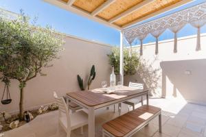 a table and chairs on a patio with a roof at Domus Afrodite - Torre Squillace in Torre Squillace