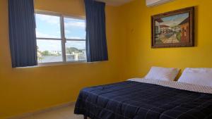 a bedroom with a blue bed and a window at Henrietta Place B&B in Progreso