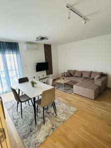 a living room with a couch and a table and chairs at Sabac City Apartman Centar S2 in Šabac