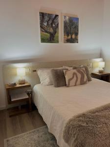 a bedroom with a bed with two pictures on the wall at Casas do Abô Fredo in Sendim