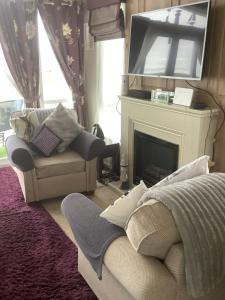 a living room with a couch and a fireplace at Home from Home in Eyemouth